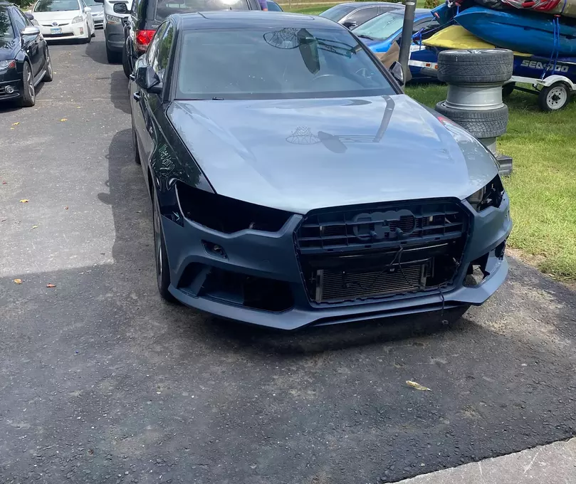 A freshly painted grey car, patiently waiting for reassembly to return to its original form, highlighting the meticulous process of automotive restoration.