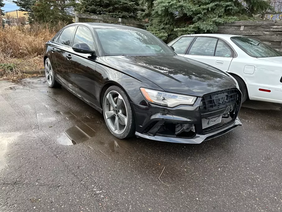 A freshly painted and fixed black car, displaying a sleek and revitalized appearance after maintenance or repairs, highlighting the attention to detail in the restoration process.