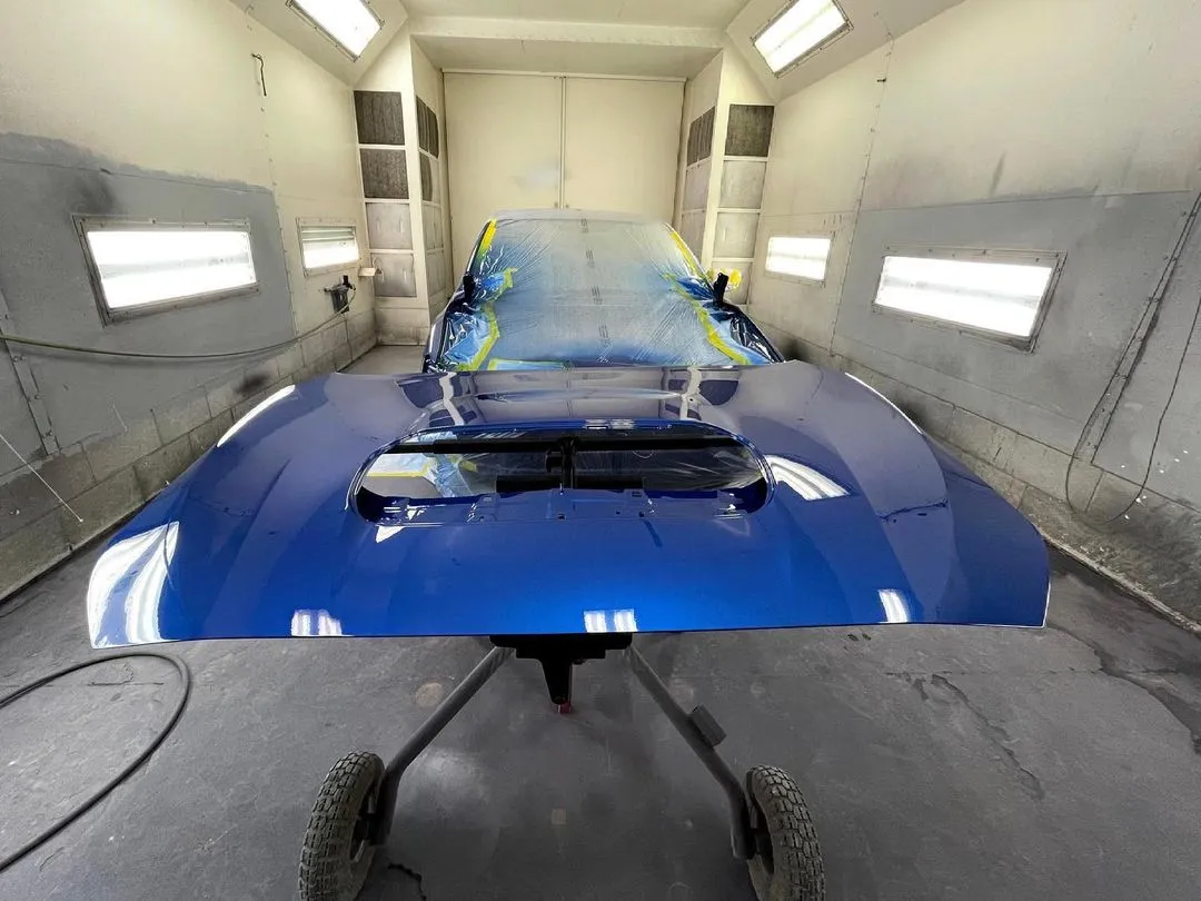 A freshly painted car hood, showcasing a vibrant blue color and a renewed appearance, reflecting the care and attention given to the painting process.