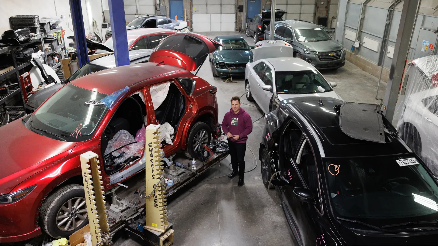 Wide overhead view of the Best Auto Body shop floor with multiple vehicles in repair