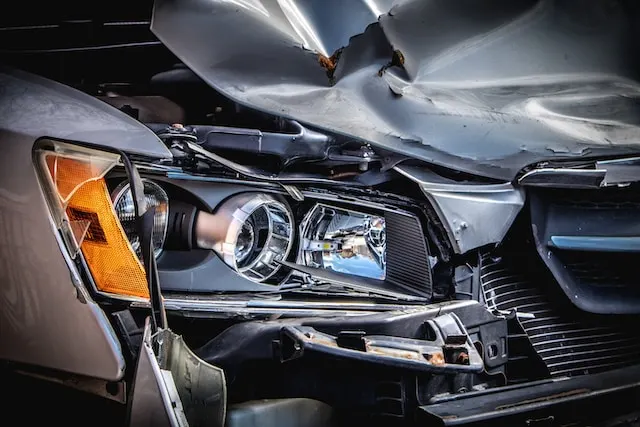 Illustrating the visible damage on the front of a silver and black car, emphasizing the need for repair and restoration.