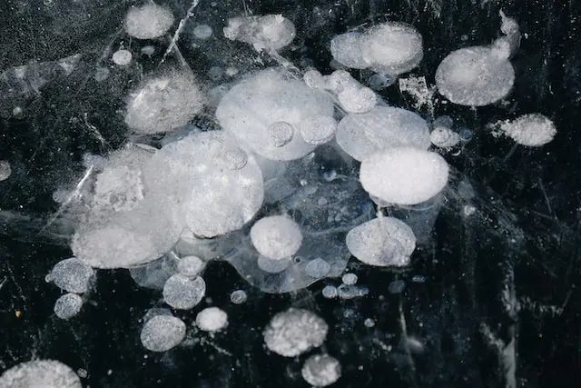 A visual representation of the effect of hail on ice, showcasing the marks and patterns created by hailstones on a frozen surface