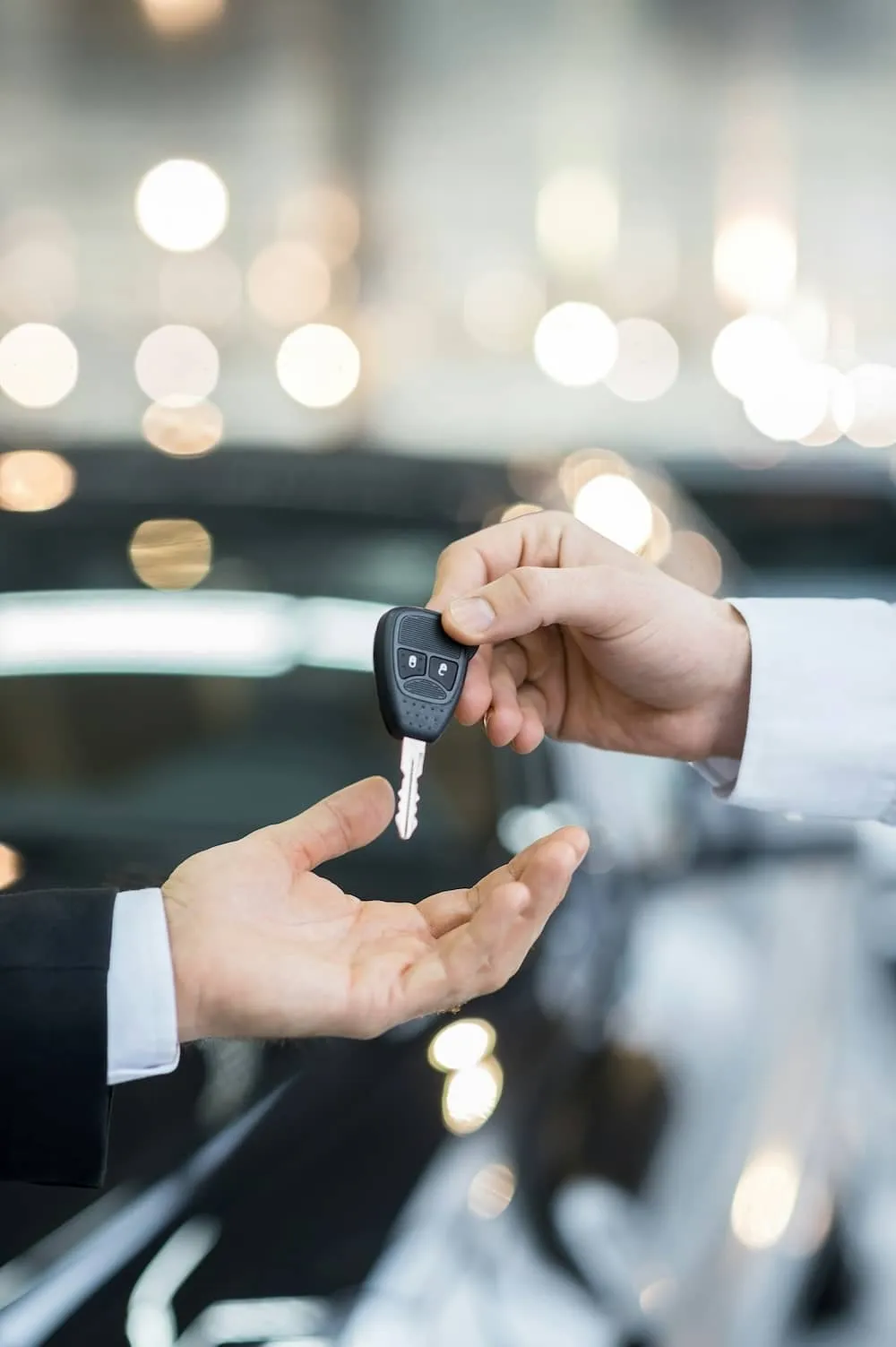 A person handing over keys to someone else.
