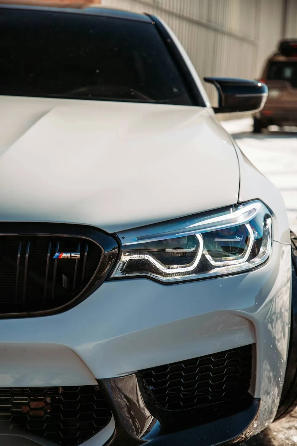 Close-up of the right headlight on a white car.
